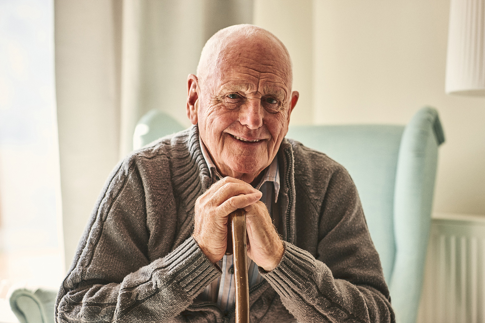 Man sitting in chair with walking stick