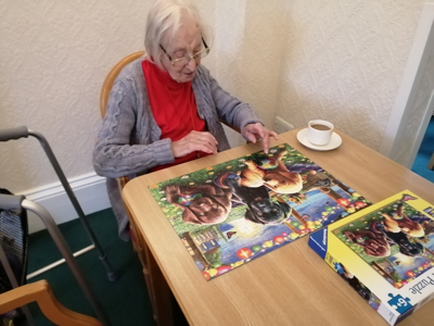 Elderly lady completing a puzzle