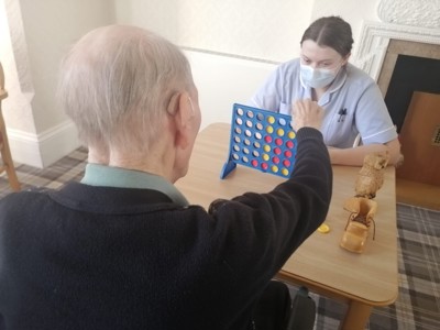 care staff playing games with elderly resident