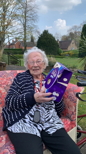 Care home resident sat in garden with easter egg