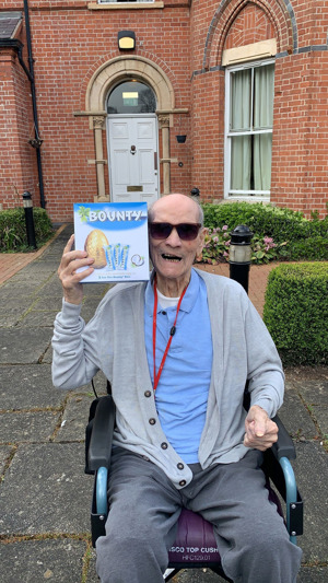 Care home resident in wheelchair celebrating with an Easter egg